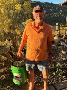 Buzz Bricca in his garden, toting his T2F compost bucket.